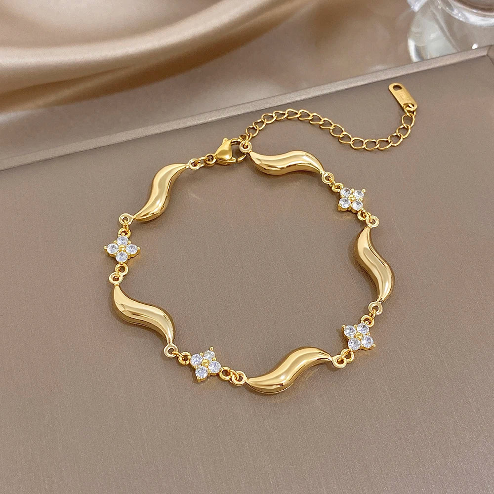 Gold-plated wave bracelet with crystal flower accents and side clasp, gold chain