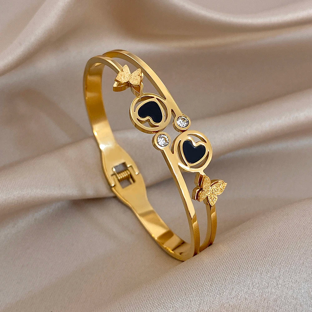 Gold-tone heart and circle butterfly cuff bangle with black enamel and crystal accents