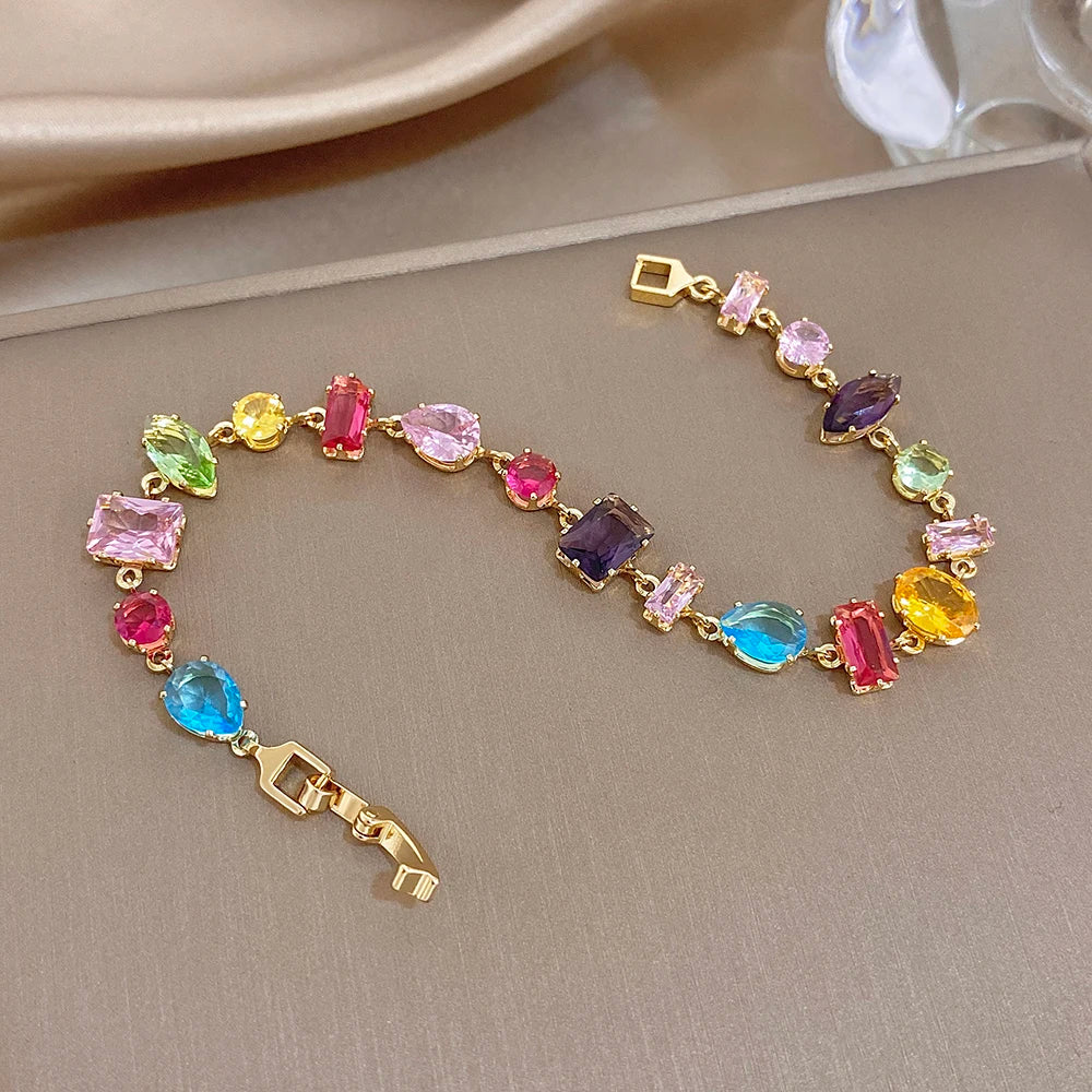 Colorful geometric zirconia bracelet with gold-tone links and multi-shape stones.