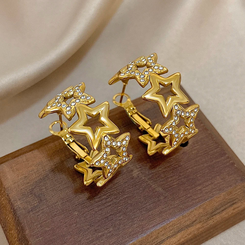 Gold-tone star hoops with open star cutouts and sparkling rhinestone details