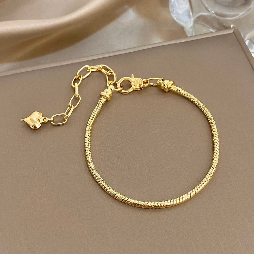 Gold-tone charm bracelet with small shell charms and lobster clasp