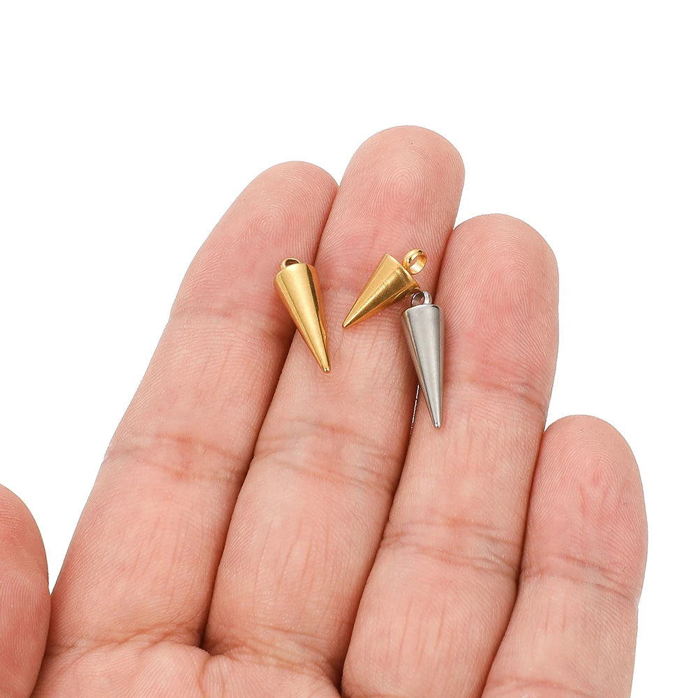 Small cone charms in gold and silver tones held in an open palm