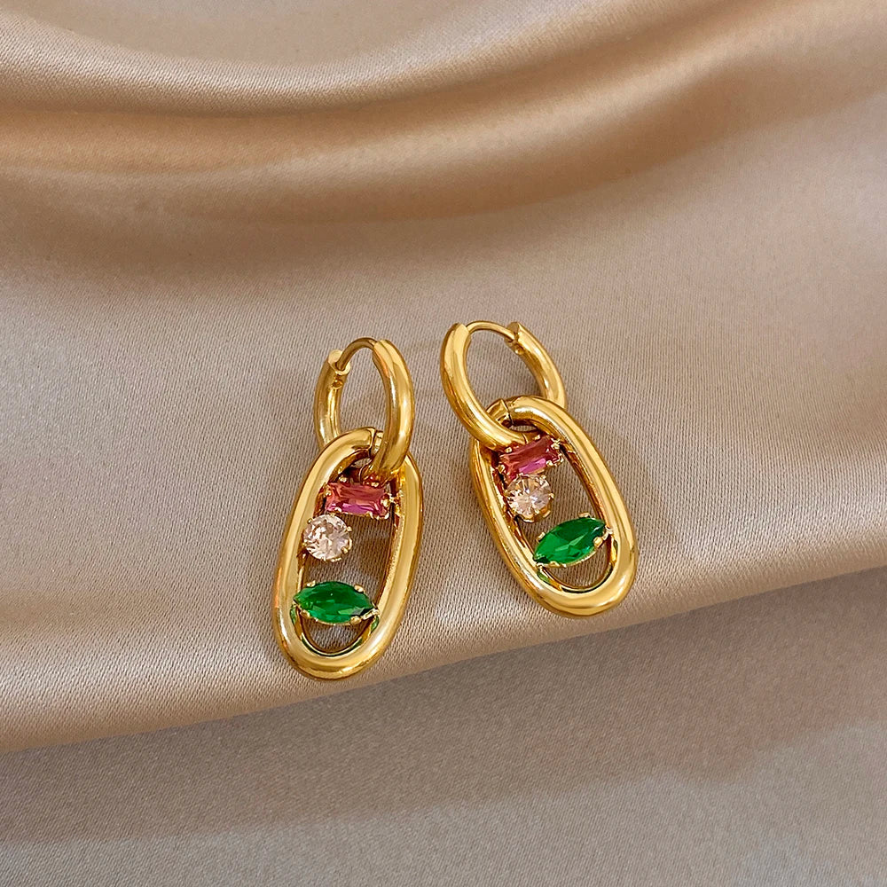 Gold hoop earrings with multicolor teardrop crystal insets: pink, green, and clear