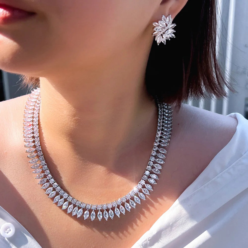 Cubic zirconia jewelry set with a leaf-shaped necklace and matching floral stud earrings, worn