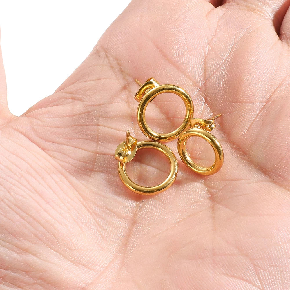 Gold round hollow stud earrings in hand, circular hoops with stud posts