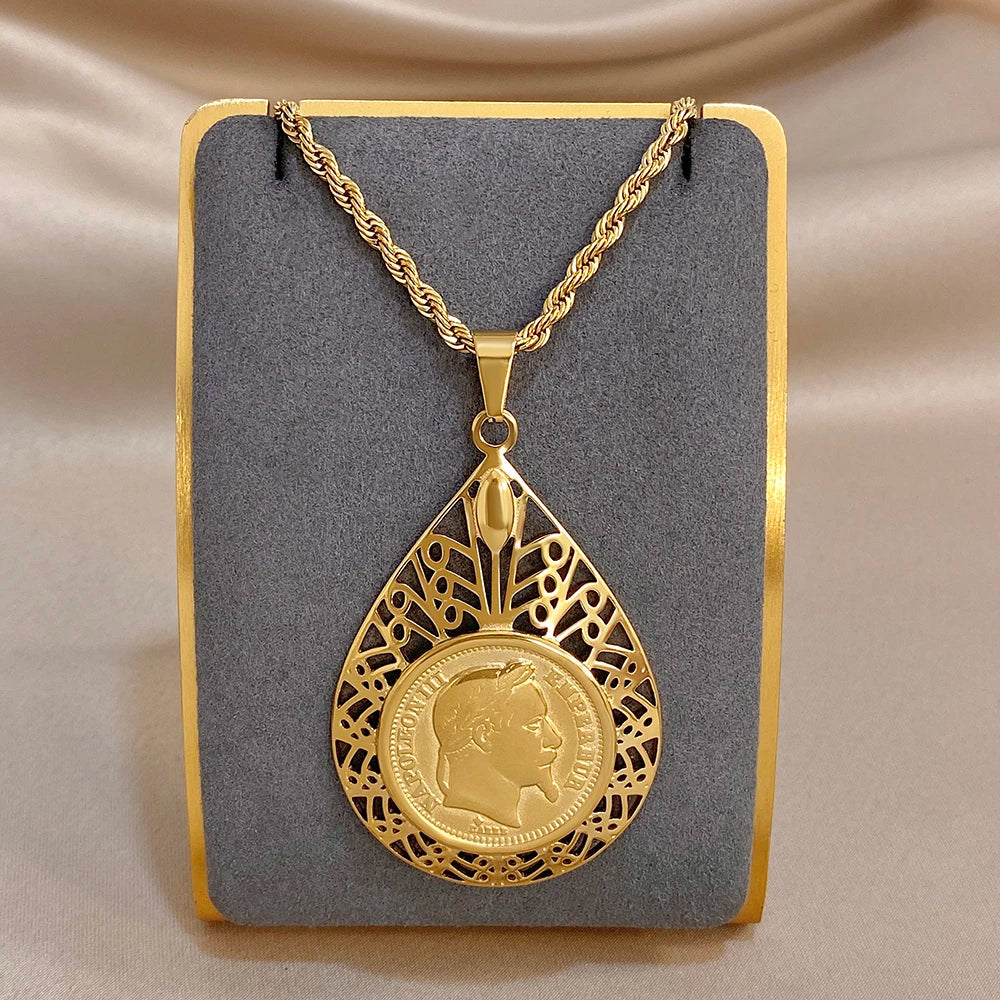 Gold-tone filigree teardrop charm necklace with lion coin center and black cutout