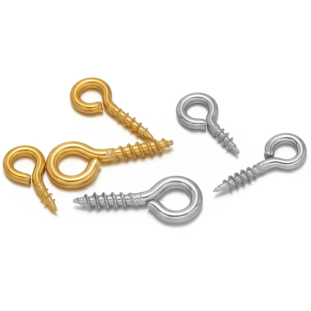Assorted gold and silver screw eye pins with threaded shafts and looped eye hooks