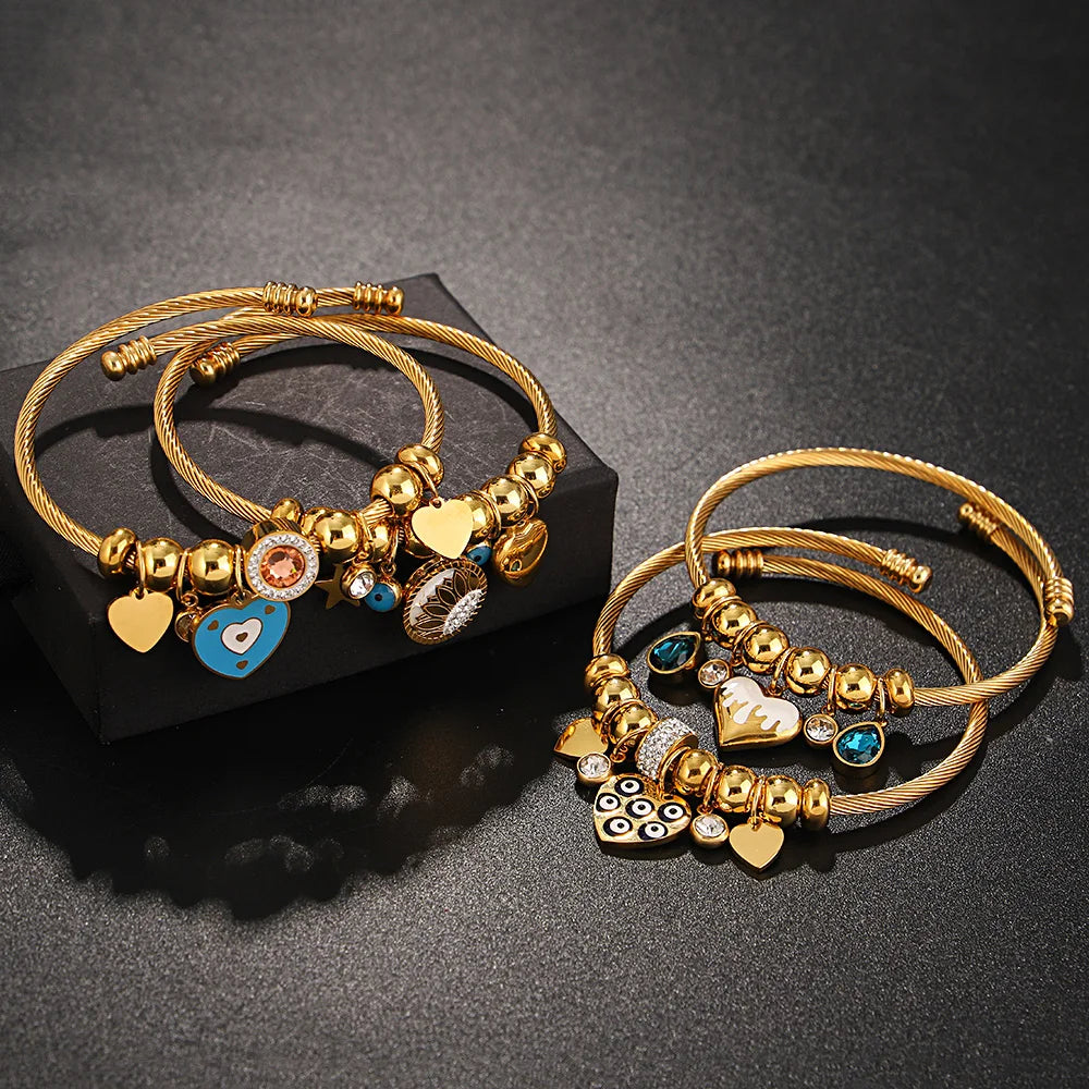 Gold-tone heart charm bracelets with blue enamel charms, crystal beads, and rings