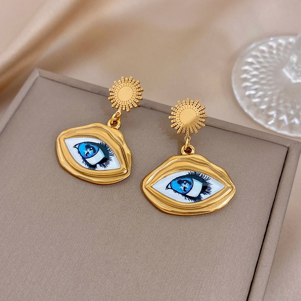 Gold-tone evil eye drop earrings with oval eye charms and sunburst stud tops