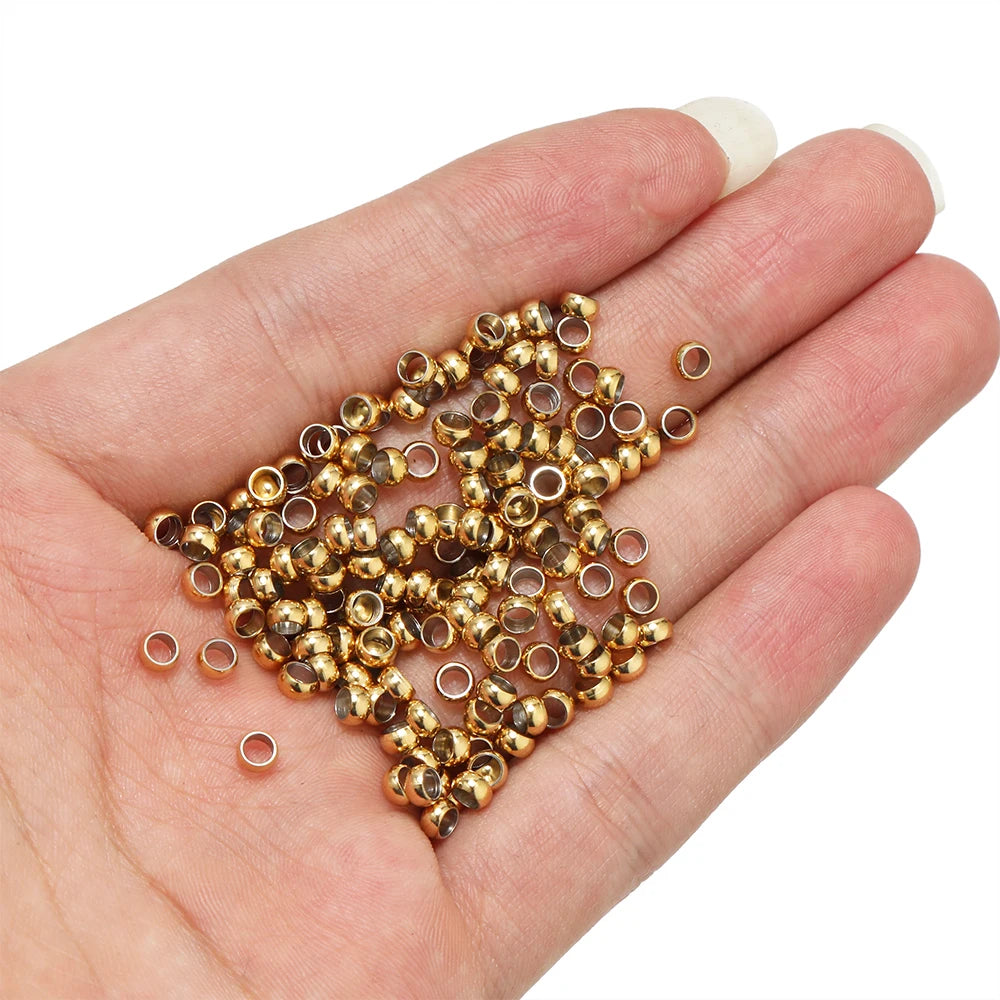 Gold-tone spacer bead stoppers poured into a hand, small round crimp ends