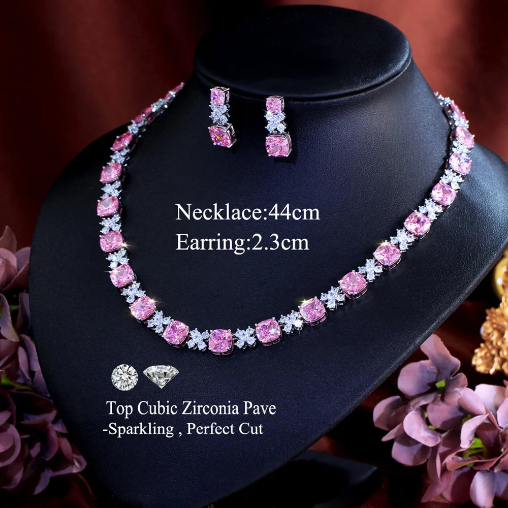 Pink square zirconia necklace with matching drop earrings set on black jewelry stand