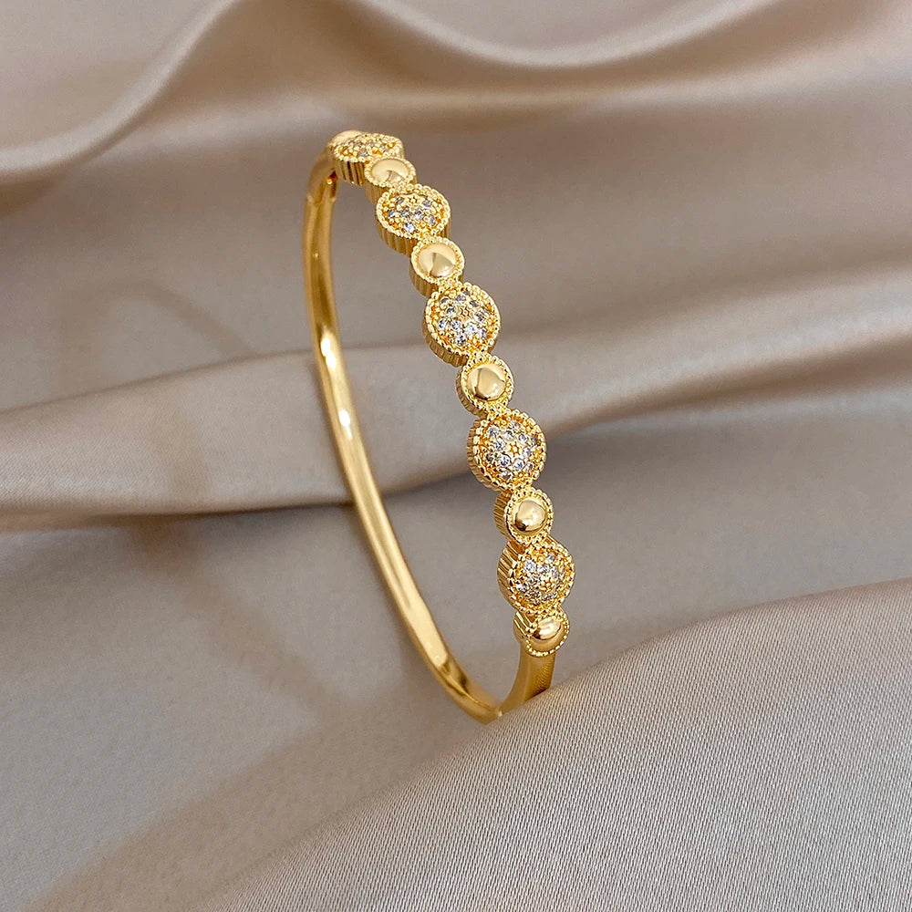 Gold-tone round zircon beaded cuff bangle with evenly spaced oval settings
