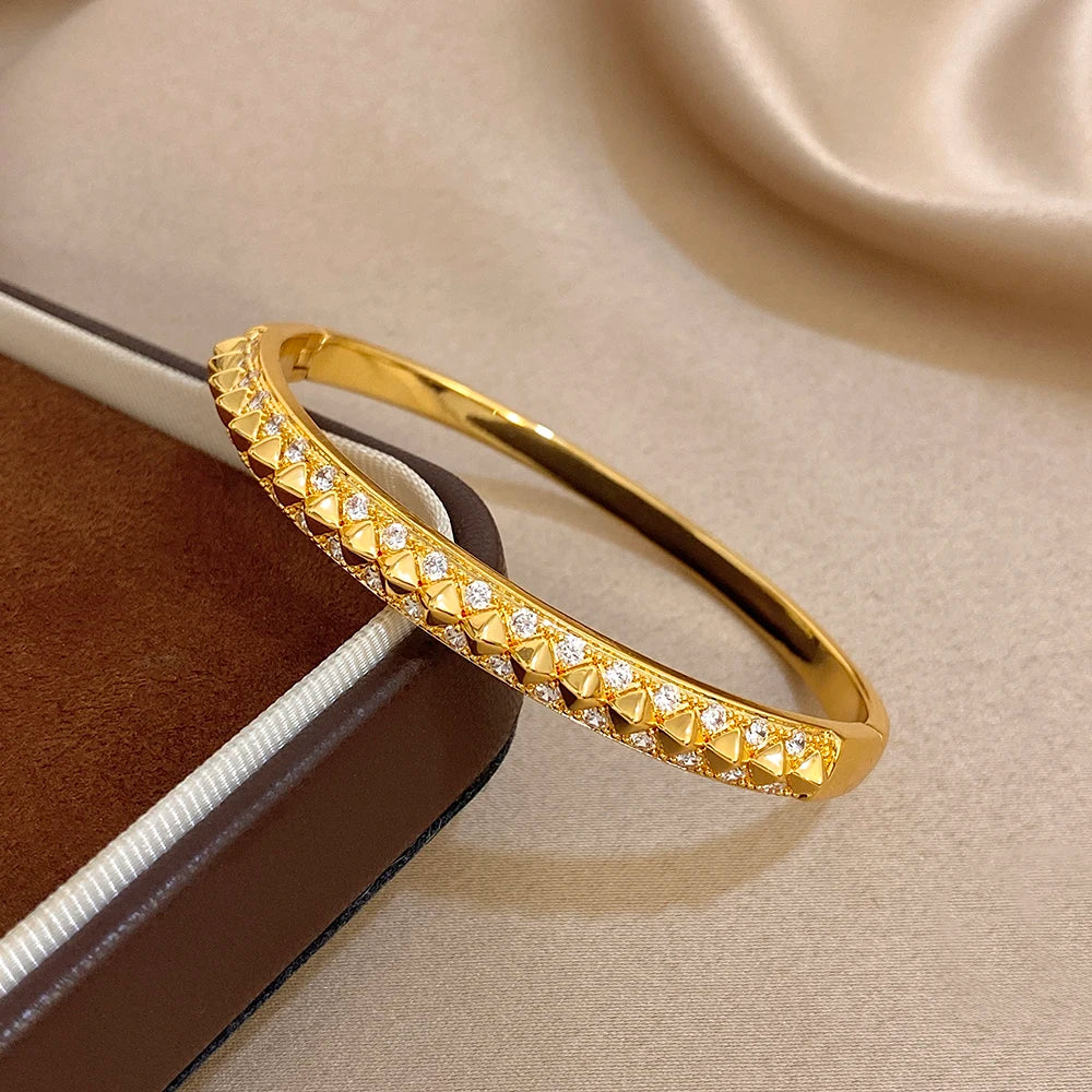Gold-plated geometric zirconia rivet cuff bangle detail with triangular stone settings