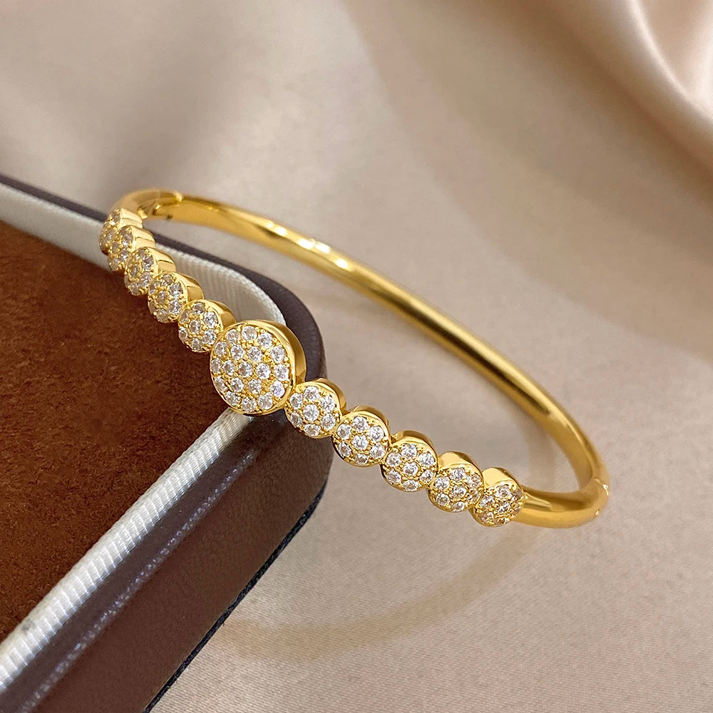 Gold cuff bangle with round pavé zircon accents