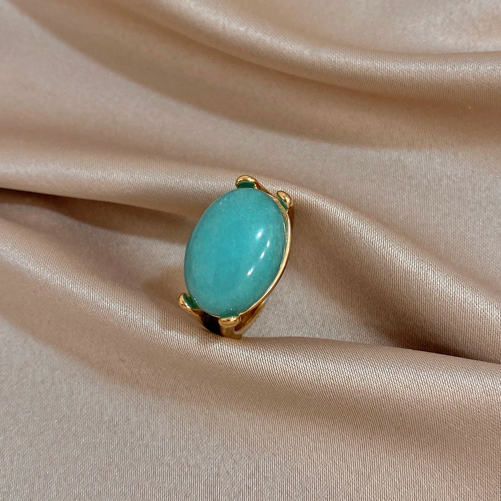 Gold-tone turquoise oval stone ring with rounded bezel setting