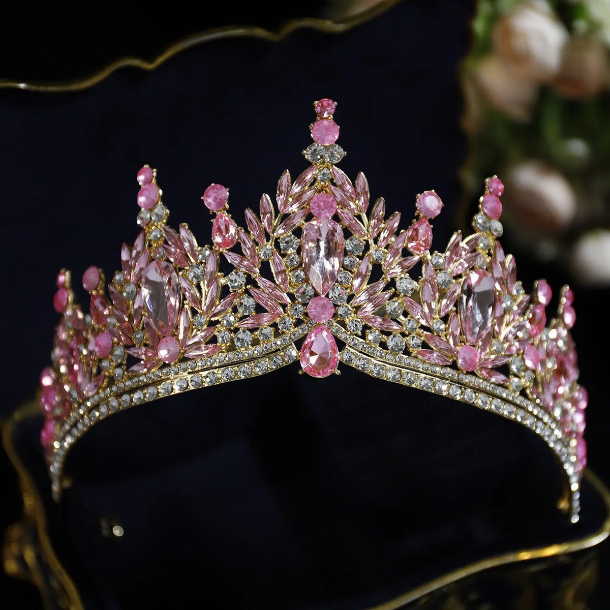 Pink crystal pageant tiara with faceted stones, rhinestone band, and leafy fringe