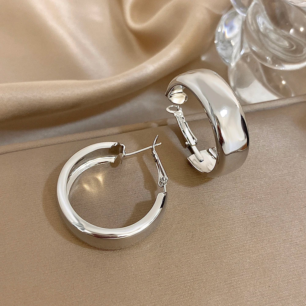 Silver-tone chunky hoop earrings with polished finish and hinged clasps