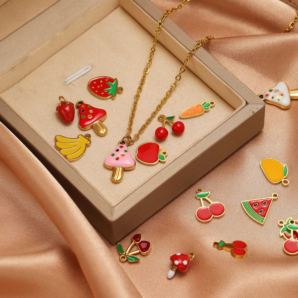 Enamel fruit charm pendants in a display box with gold-tone hanging loops, assorted set