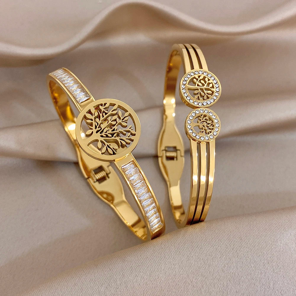 Gold-tone bracelet set with tree-of-life charm, clear stone strips, and stacked cuffs