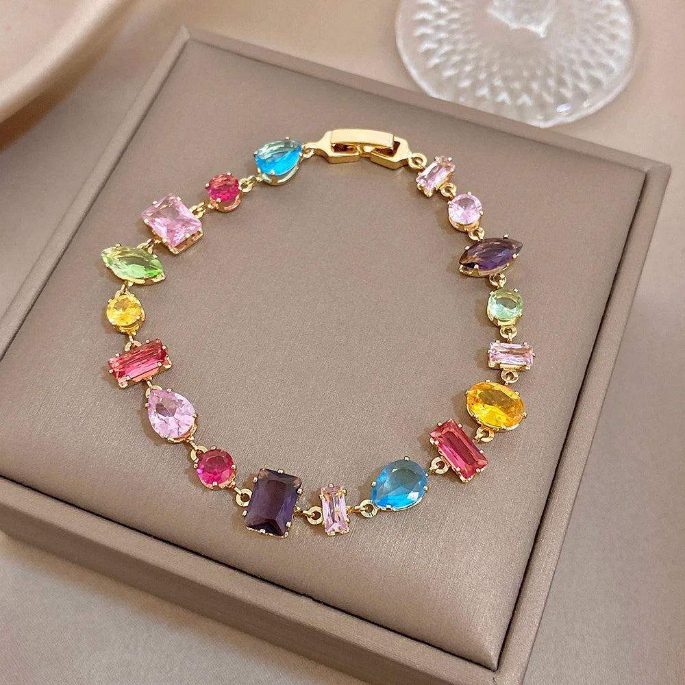 Gold-tone zirconia link bracelet with multicolor faceted stones and secure clasp.