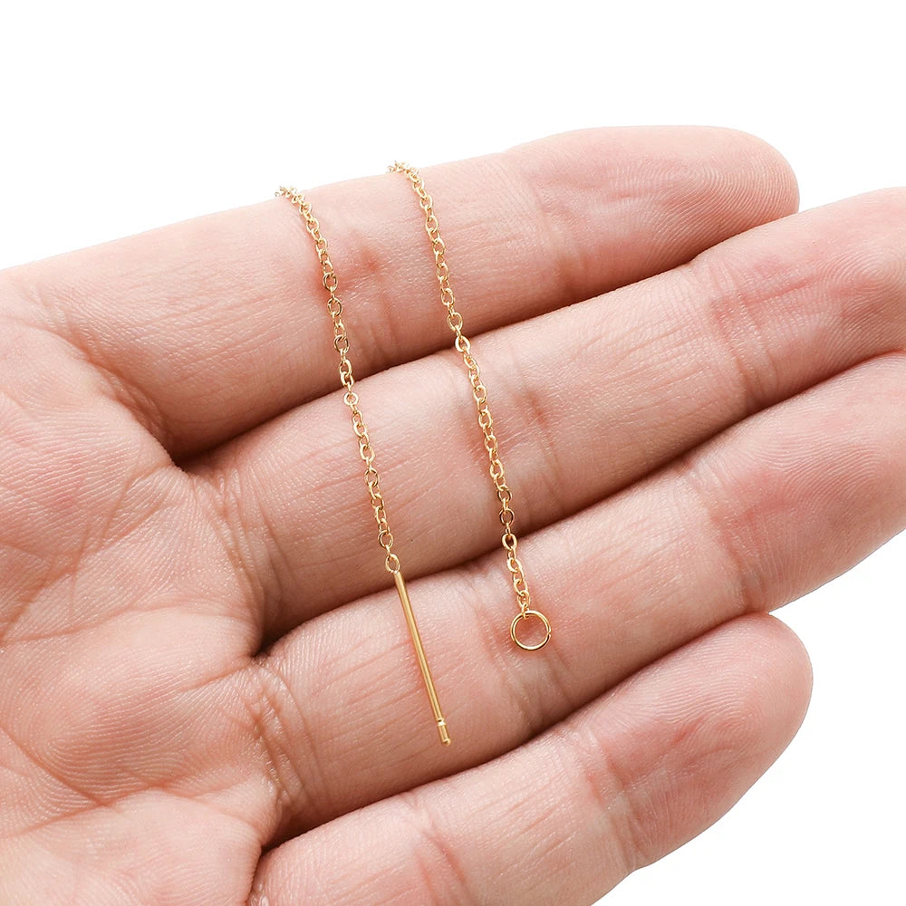 Gold-tone chain ear-line earrings with straight bars and loop closures, on hand