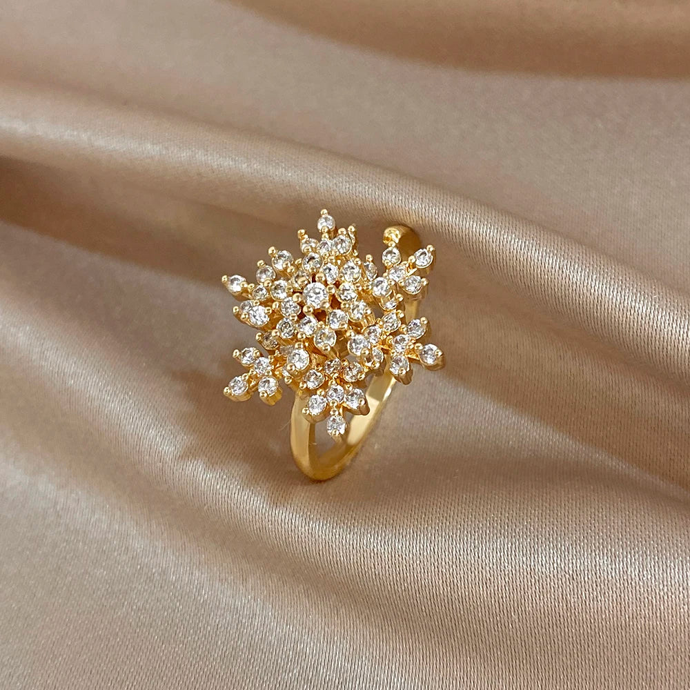 Gold-plated snowflake flower ring with clear round zirconia stones on a slim band