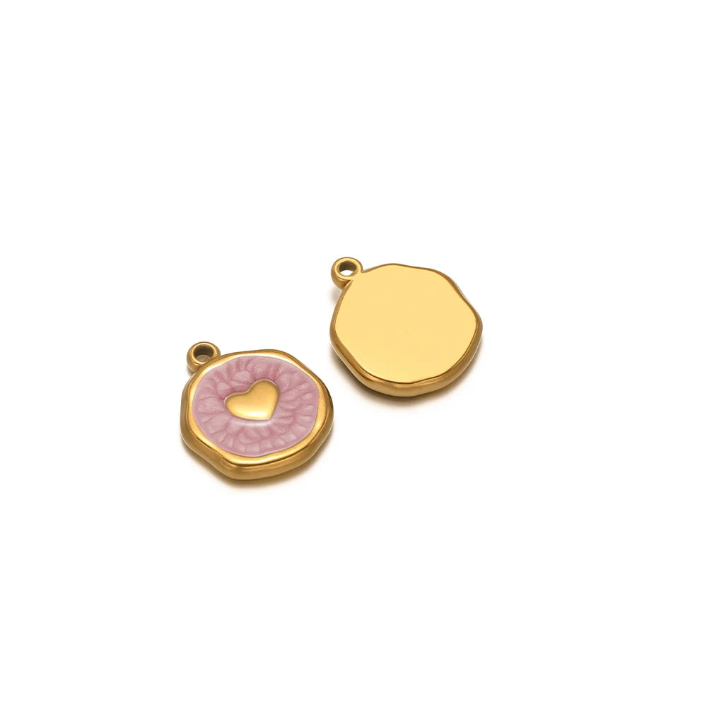 Two gold-tone enamel charms: mauve heart with hand motif and plain gold back