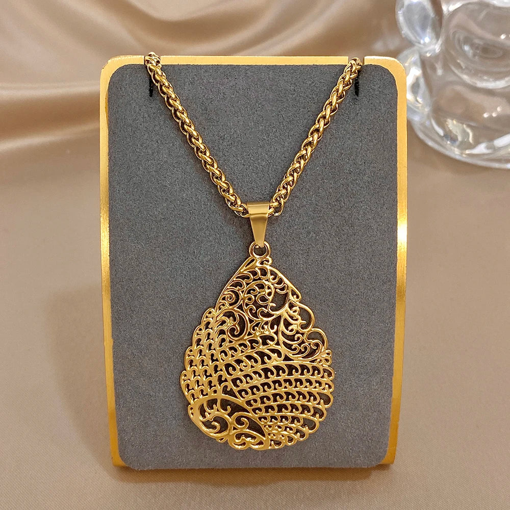 Gold-tone hollow heart pendant necklace with swirling filigree design