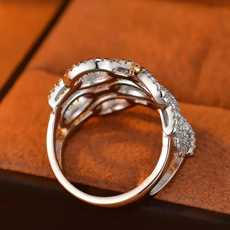 Silver-tone ring with round crystal bezel and openwork side link design