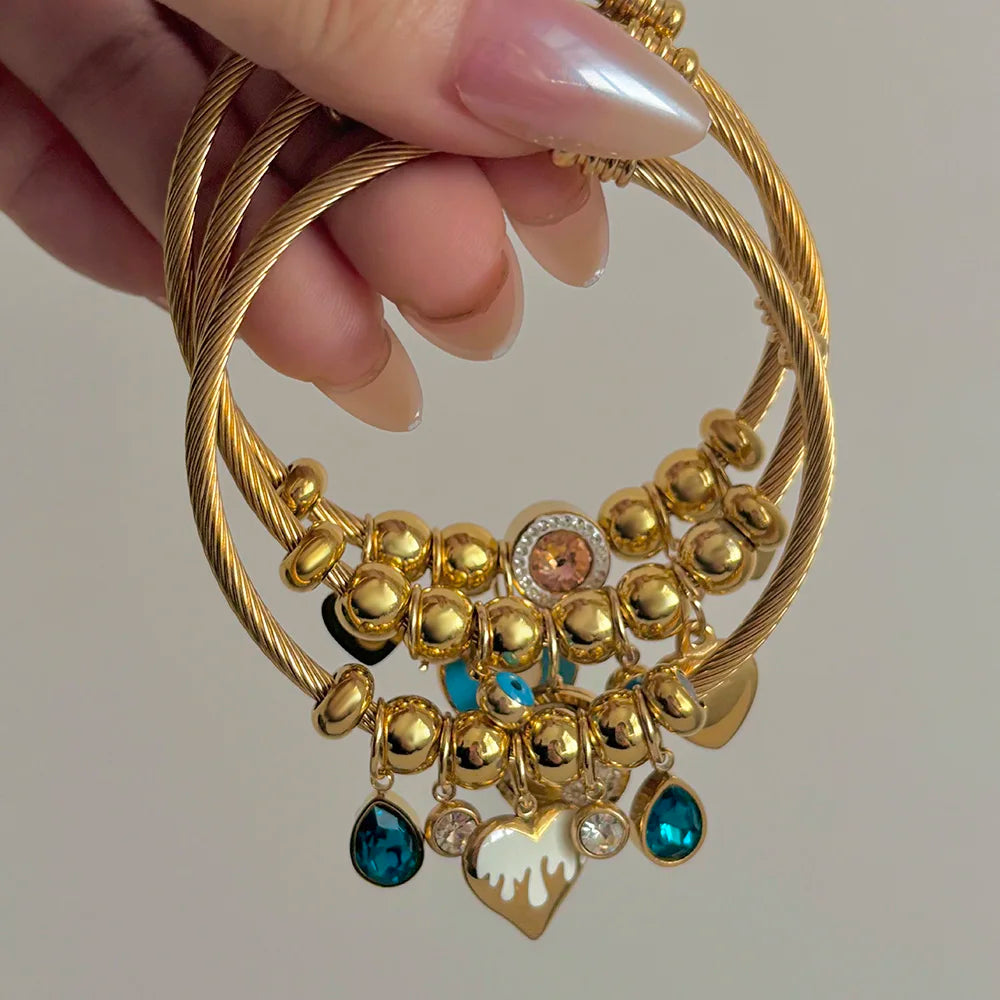 Gold-tone braided charm bracelet with crystal beads and heart/blue heart charms
