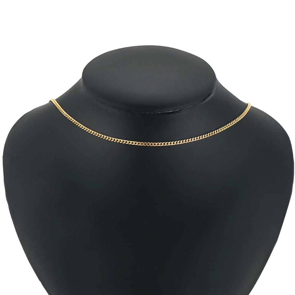 Gold curb Cuban link chain necklace on black display mannequin