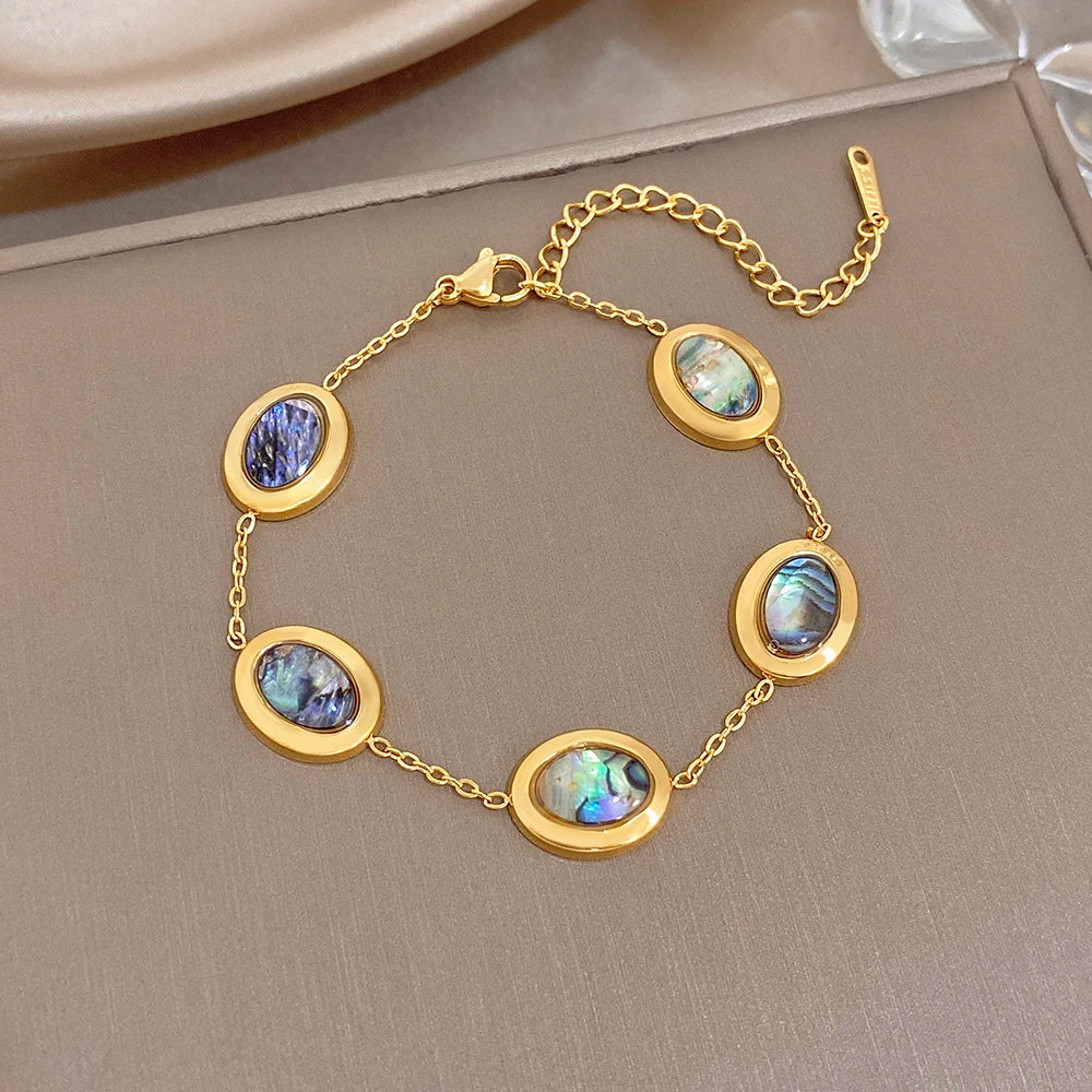 Gold plated oval chain bracelet with blue and iridescent abalone shell discs