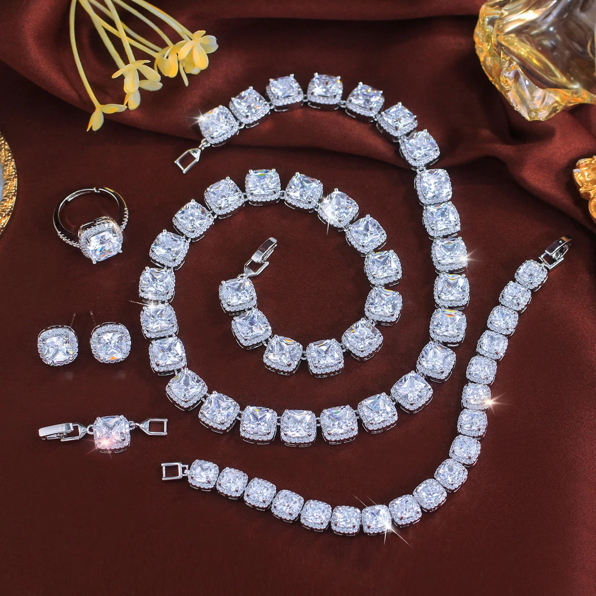 Clear CZ tennis necklace, bracelet, and stud earrings set in silver-tone, oval stones