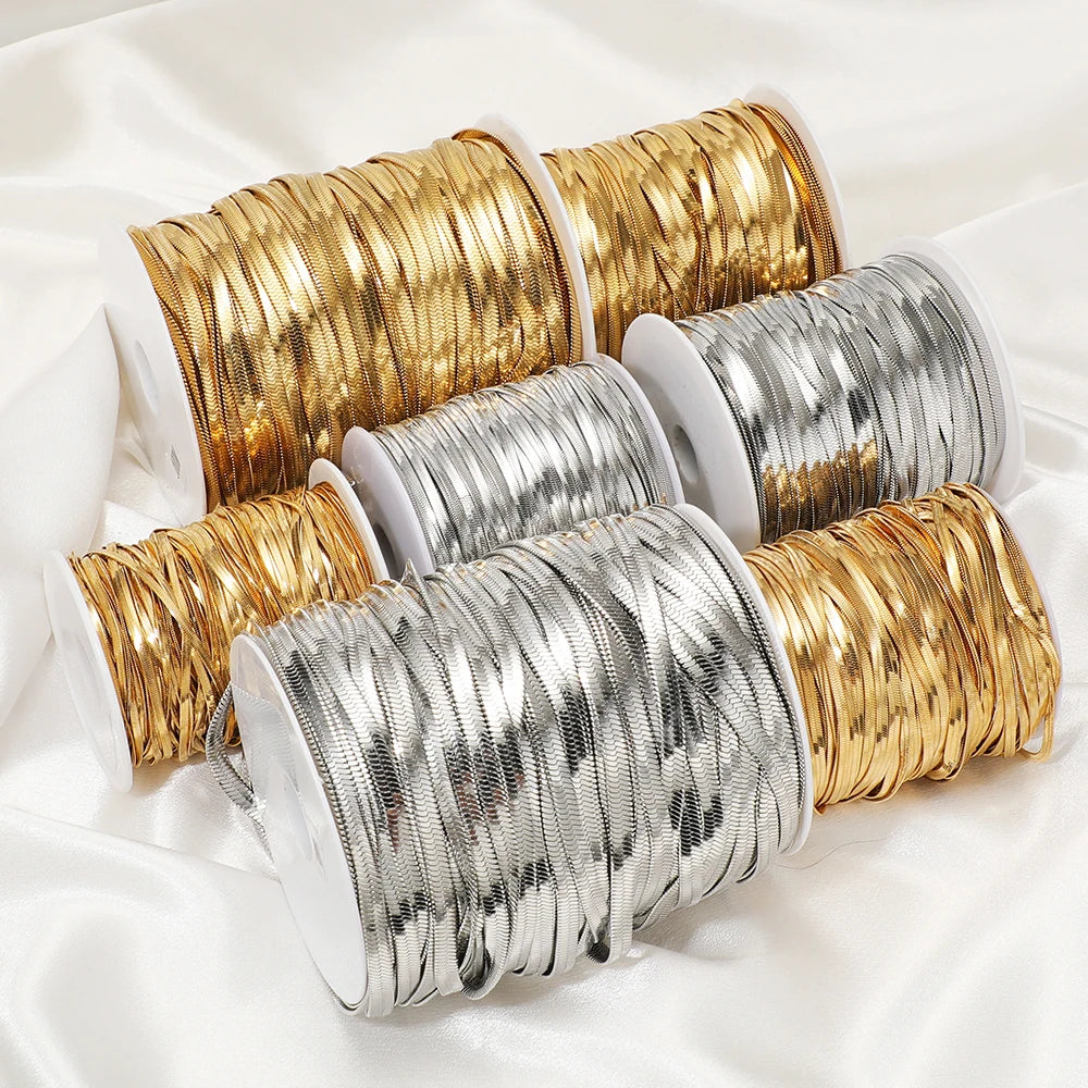 Assorted flat snake chain cords on spools in gold and silver for crafting