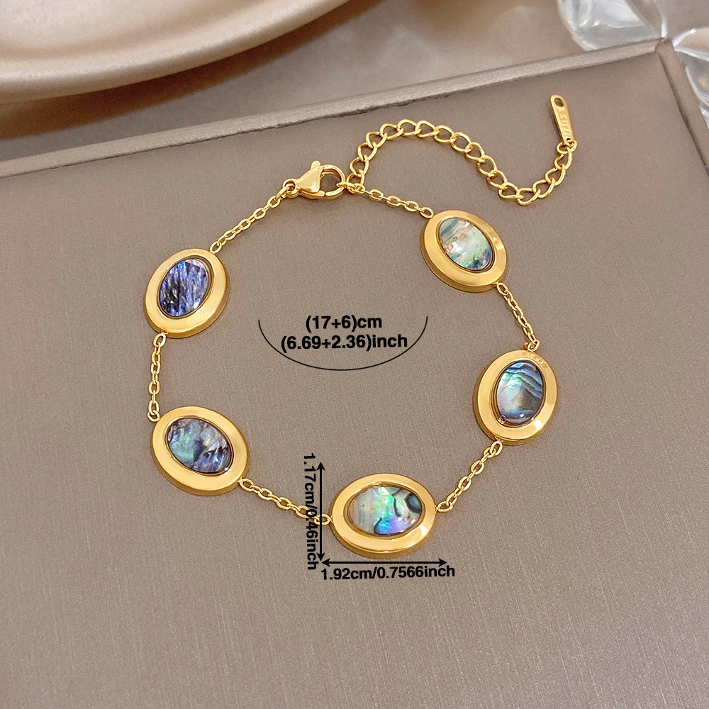Gold plated abalone shell oval charm bracelet, blue and iridescent discs on chain