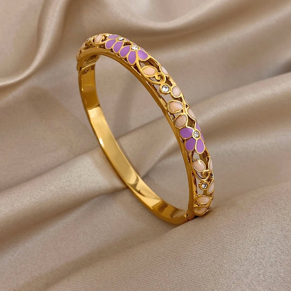 Gold-plated cuff bangle with purple enamel inlay and white oval cutouts with crystals