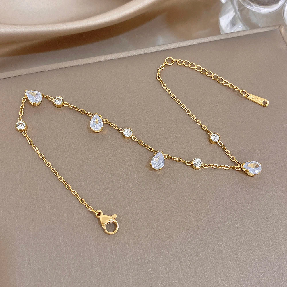 Gold-tone bracelet with teardrop and round zircon links, side view