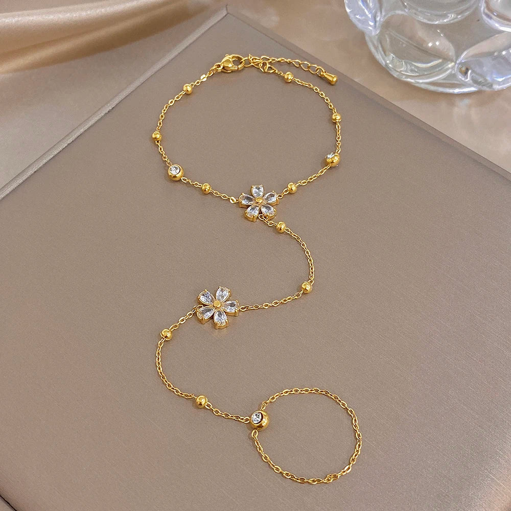 Gold-plated flower charm bracelet with connected finger ring chain