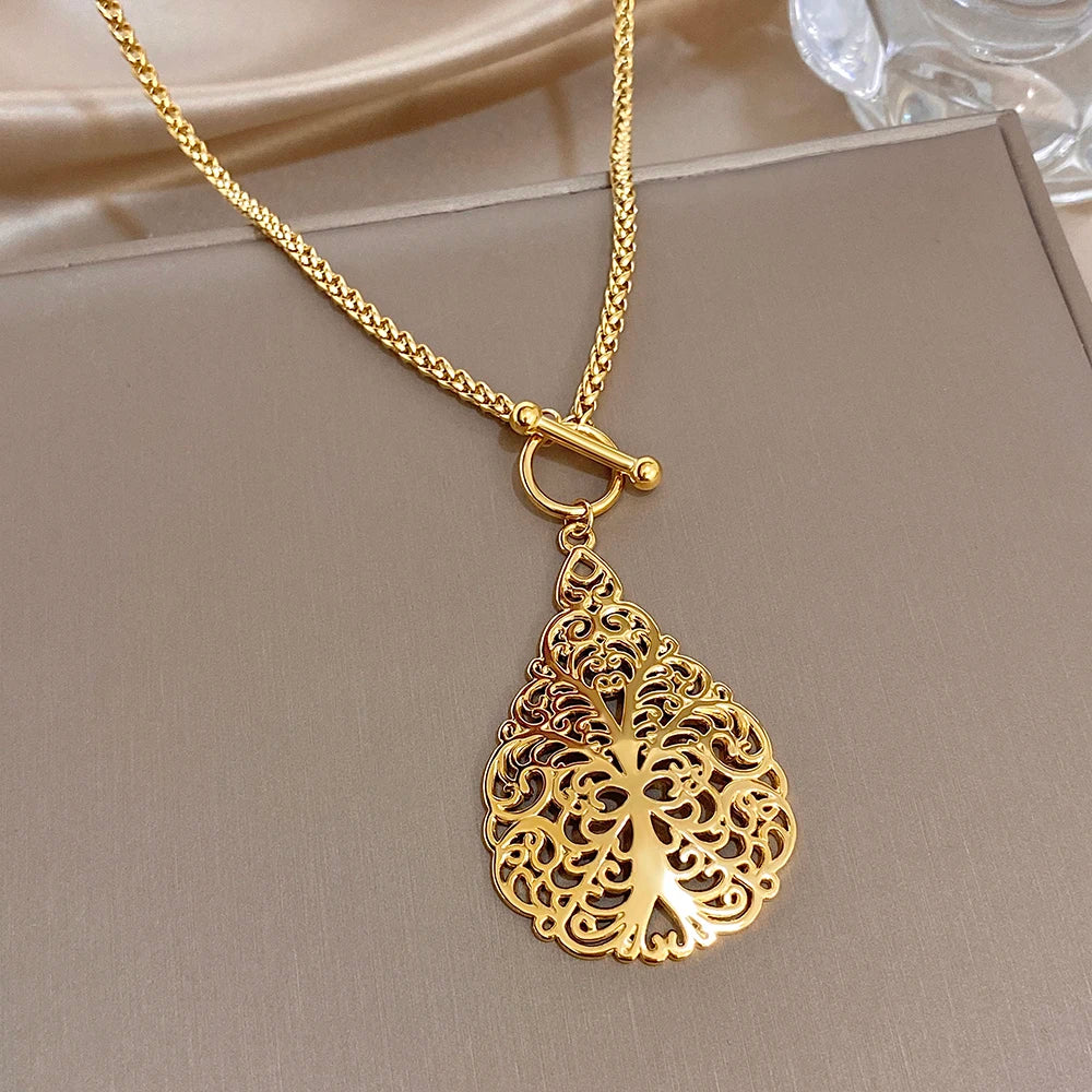 Gold-tone waterdrop filigree pendant necklace with small looped bail detail