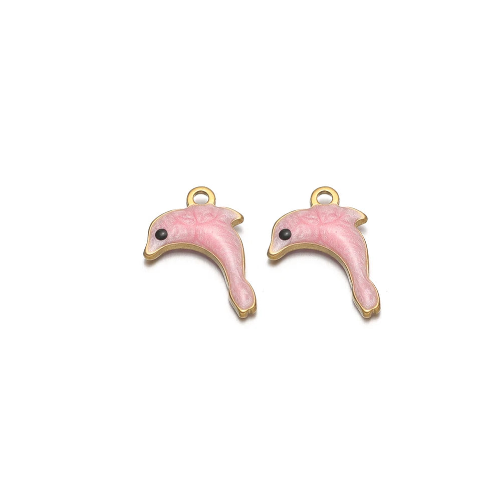 Two pink enamel dolphin charms with gold-tone loops and small eyes