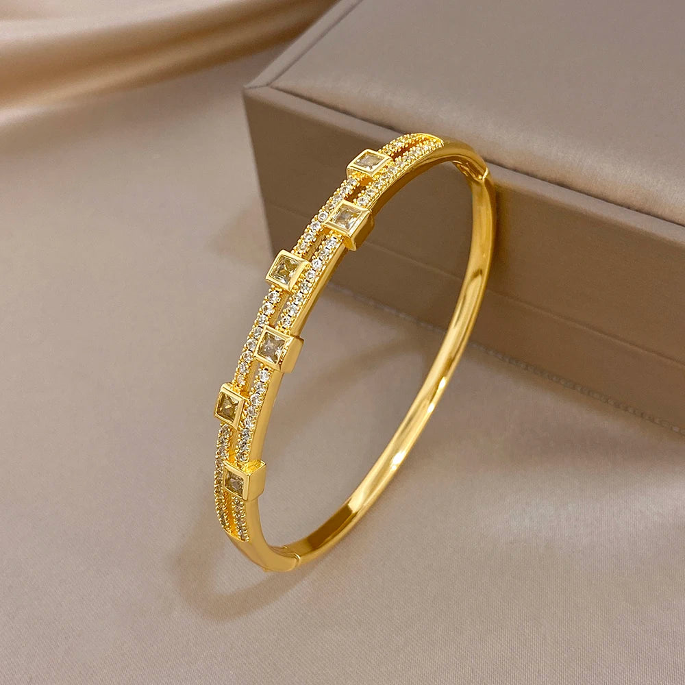 Gold-tone rhinestone bangle bracelet with rectangular square settings, angled view