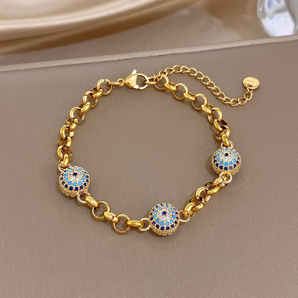 Gold-tone chain bracelet with blue evil-eye bead charms and spring-ring clasp