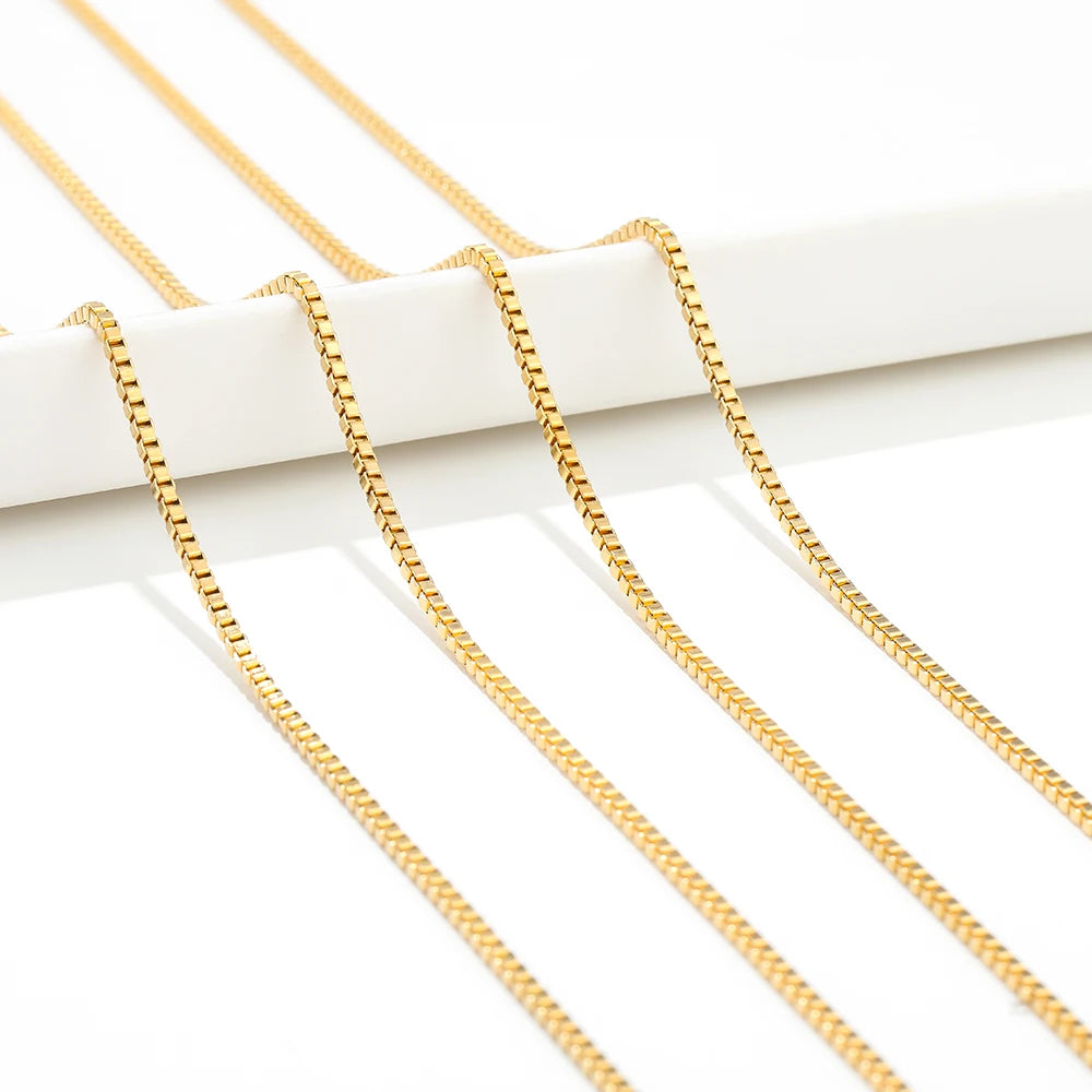 Gold box chain strands draped over a white organizer bar, ready for DIY jewelry
