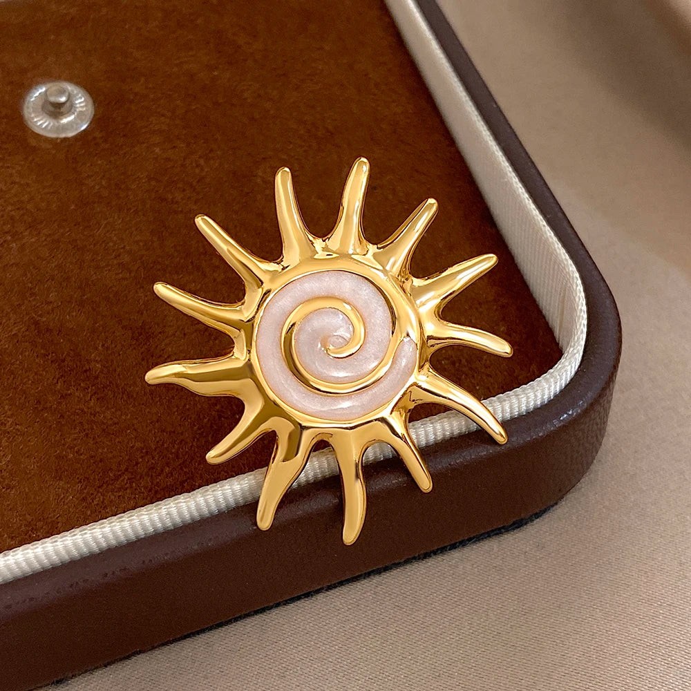 Gold-plated sunburst ring with pale lavender spiral enamel on gift box