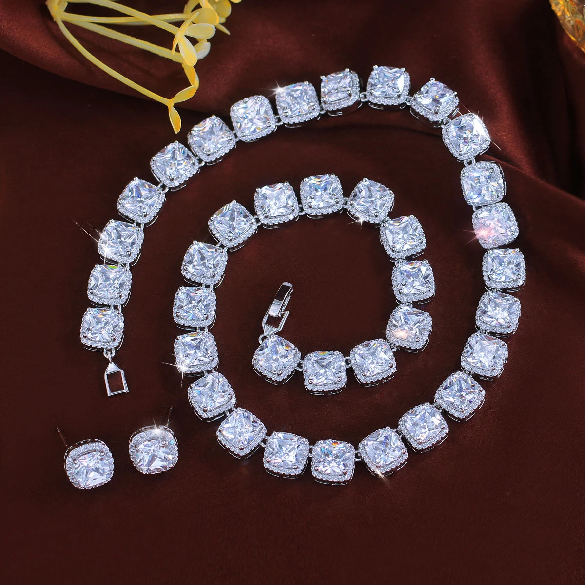 White square zirconia necklace, bracelet and matching stud earrings arranged as a set