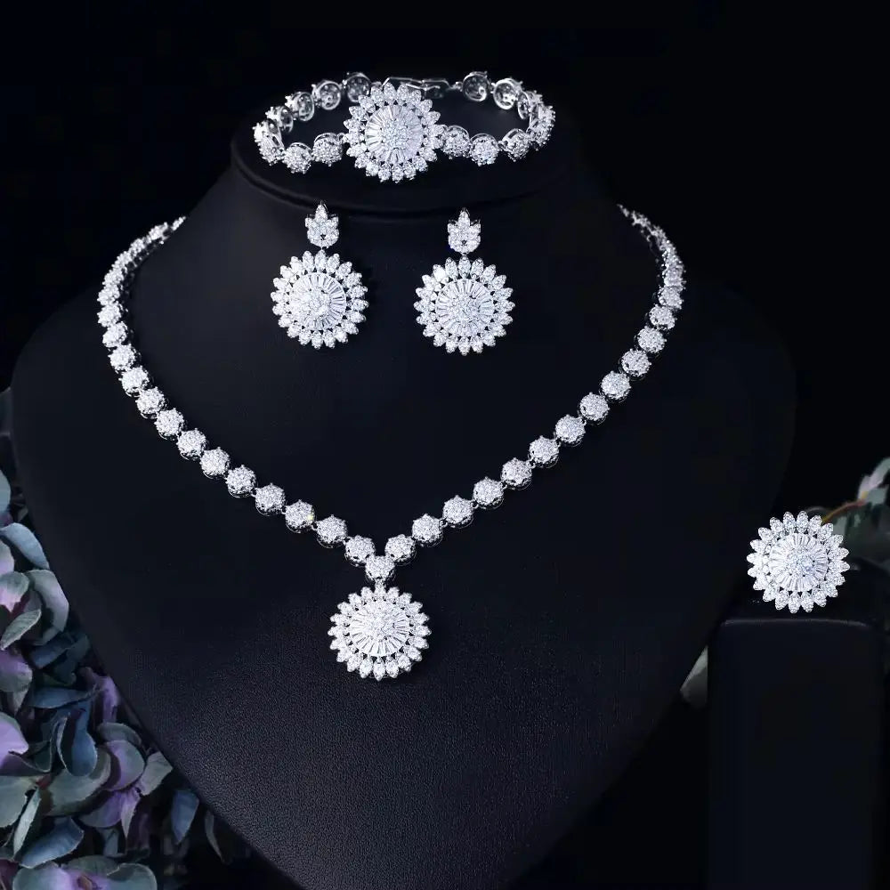 Sunflower zirconia jewelry set on stand: sparkling necklace, bracelet, dangling stud earrings.