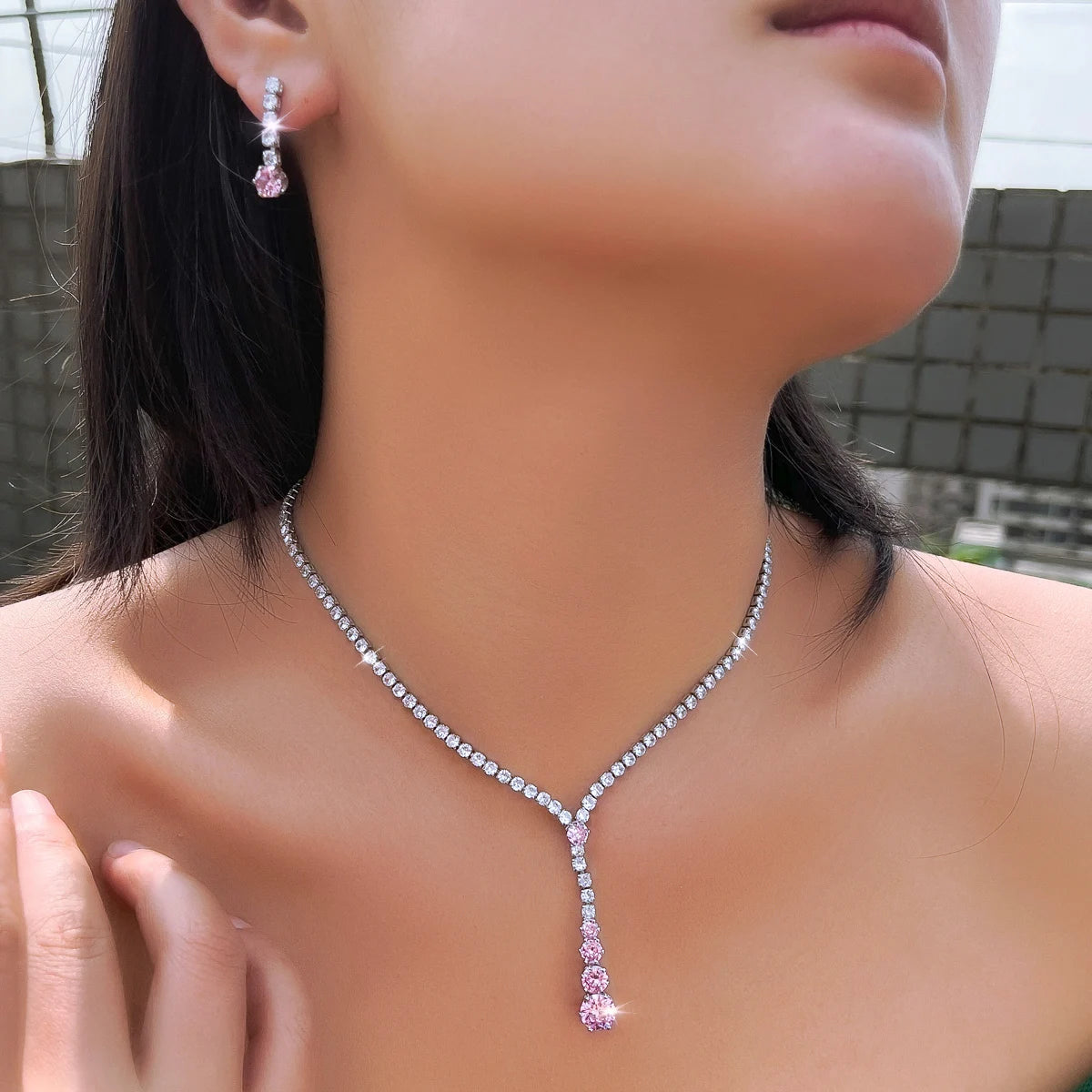 Y-shaped cubic zirconia necklace and pink drop earring modeled on a wearer