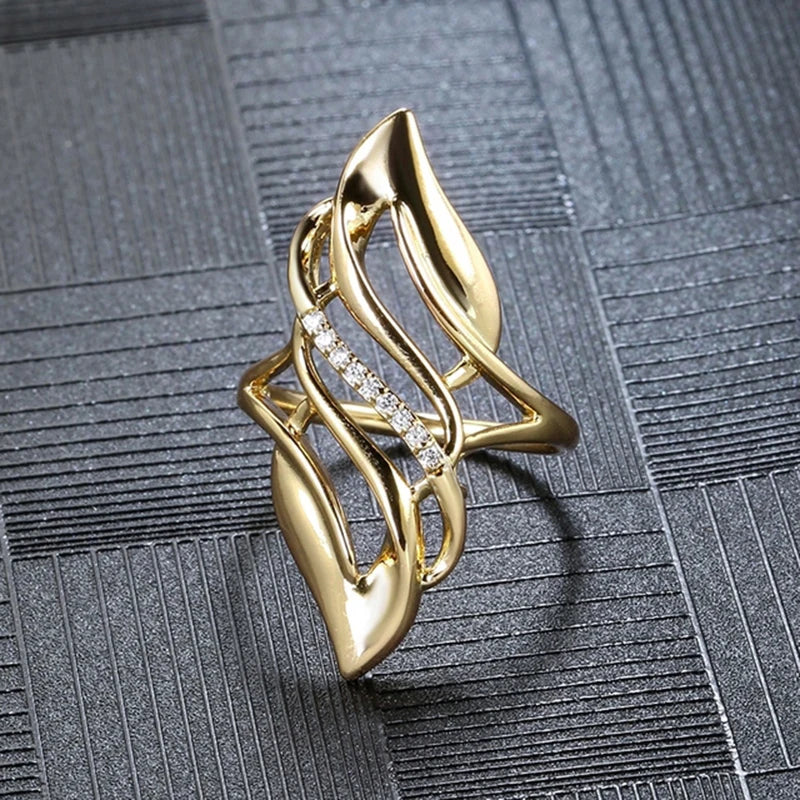 Gold-tone hollow geometric ring with crystal pave center and curved shield cutouts