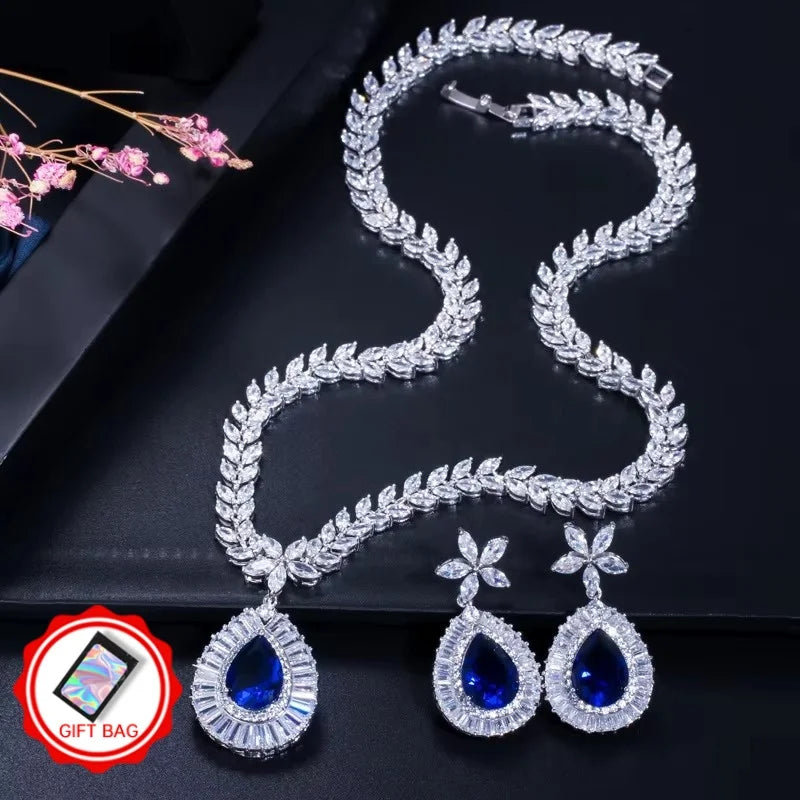 Blue teardrop zircon necklace and matching flower-stud earrings, with gift bag icon