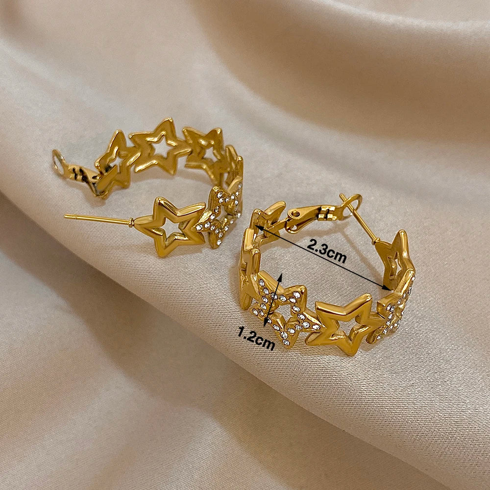 Star hoop earrings with hinged posts; hoops measure 2.3 cm across and 1.2 cm wide